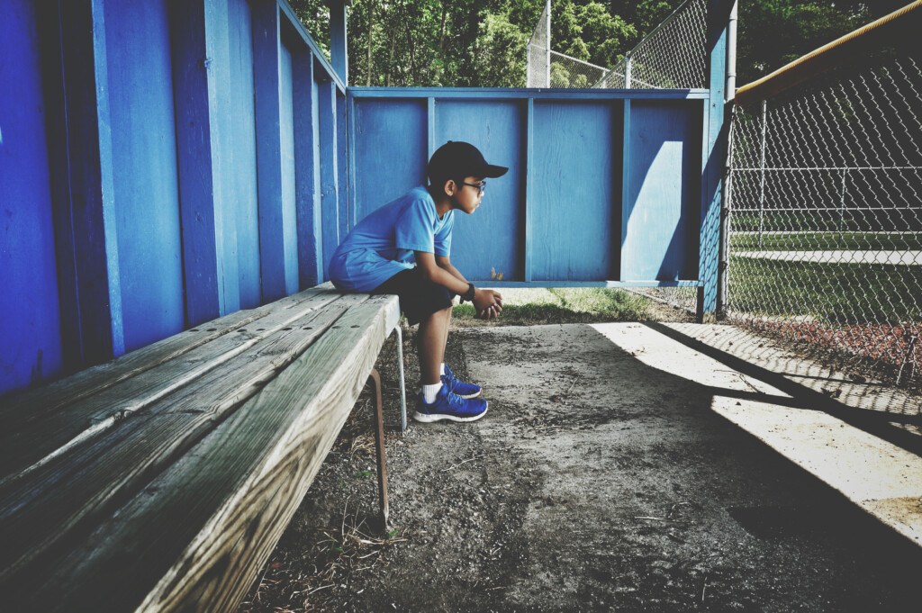 boy sitting alone on bench, for article on child being left out