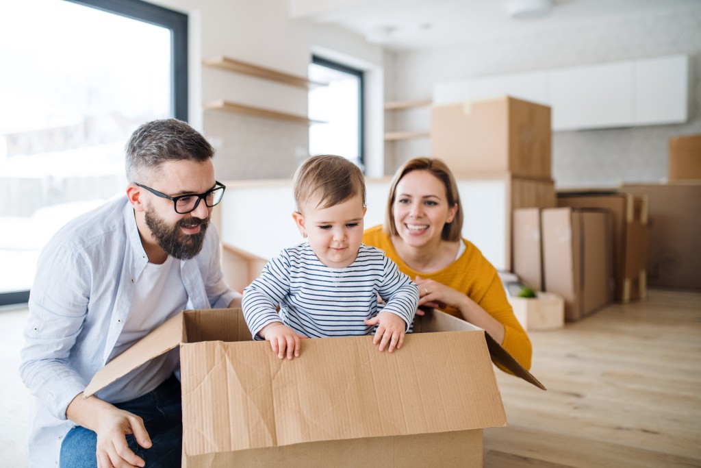 moving with toddlers. young parents with toddler in moving box