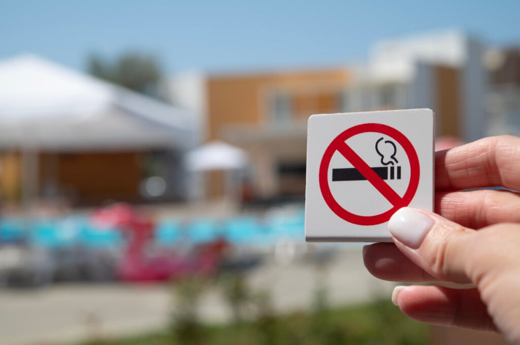 A Woman's Hand Holds A No Smoking Sign.