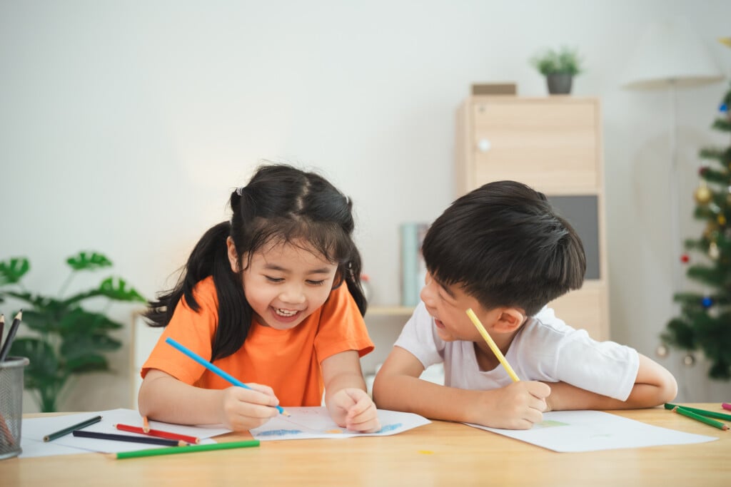 two preschool children having fun working together in classroom