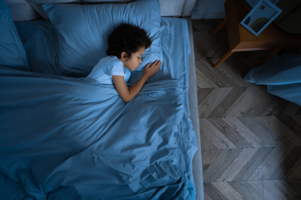 a young boy sleeping in his room at night