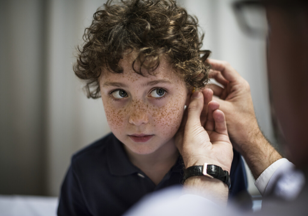 young child having his ears checked, for article on undetected hearing loss