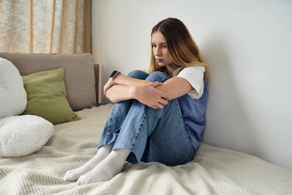 a teenager looking sad in her bedroom