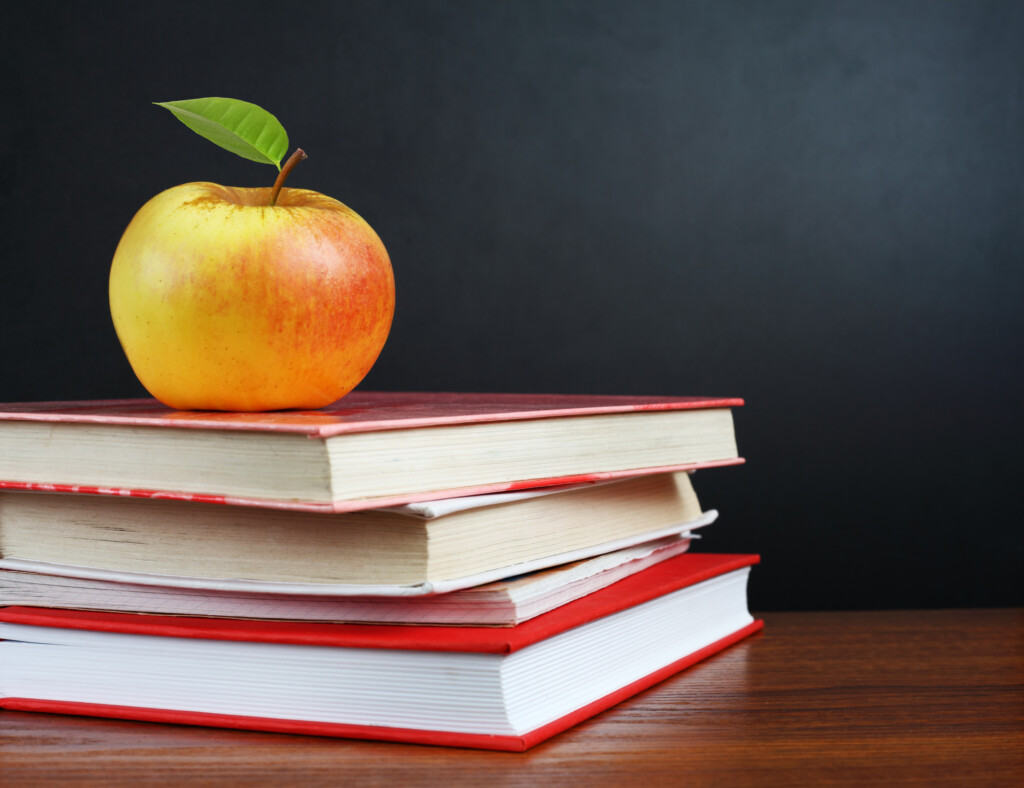 a teacher's desk with books and an apple