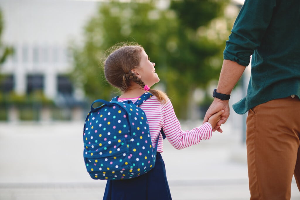 father and young girl with backpack, for article. on choosing a school