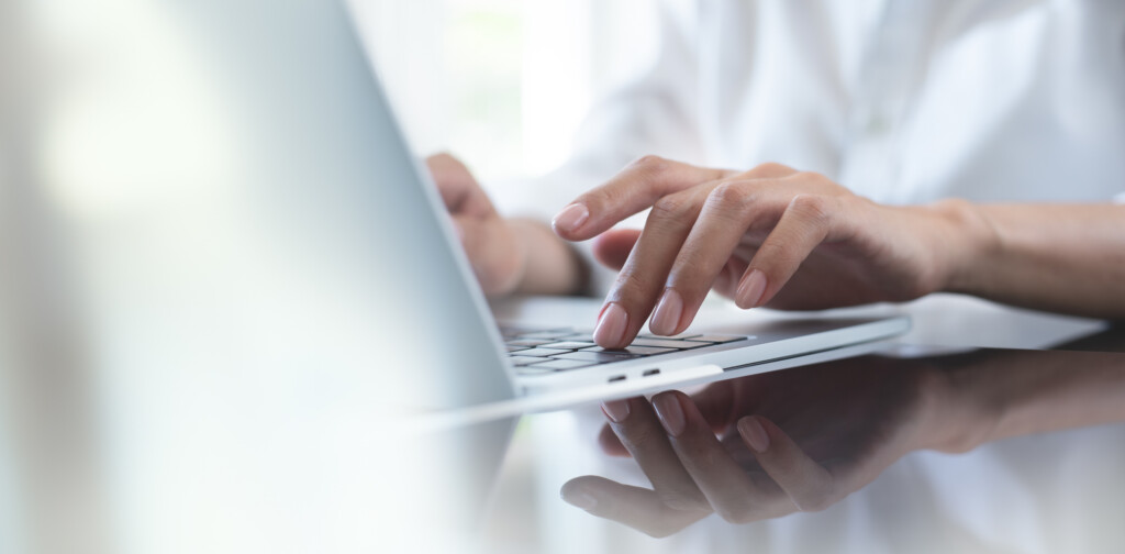close up of woman typing on laptop