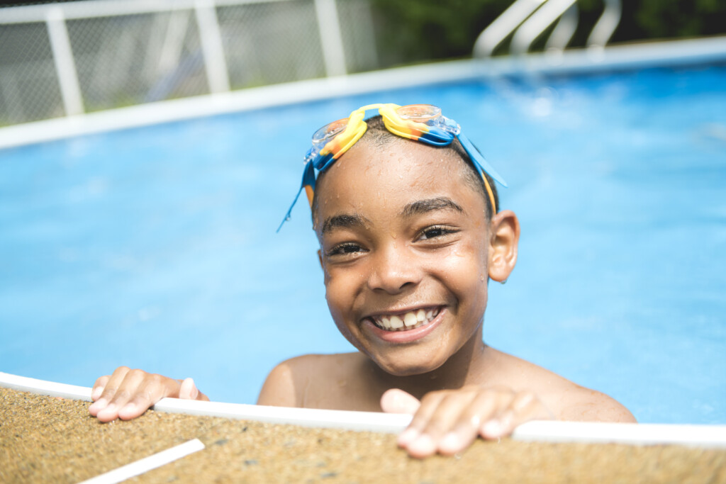 child smiling in swimming pool