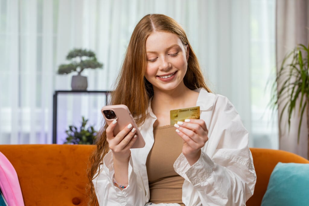teen girl holding phone and credit card