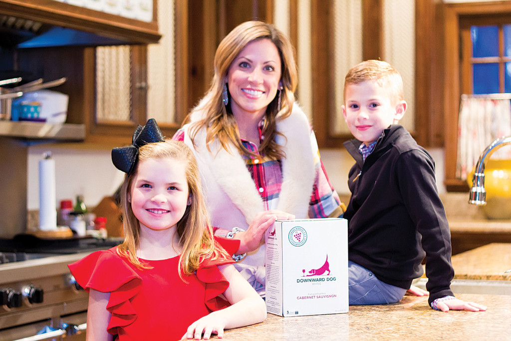 betsy hendershot with her children and a box of downward dog wine