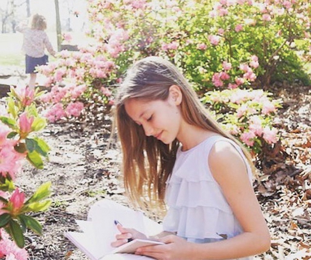 a girl reading in a beautiful outdoor environment. charlotte mason learning concept
