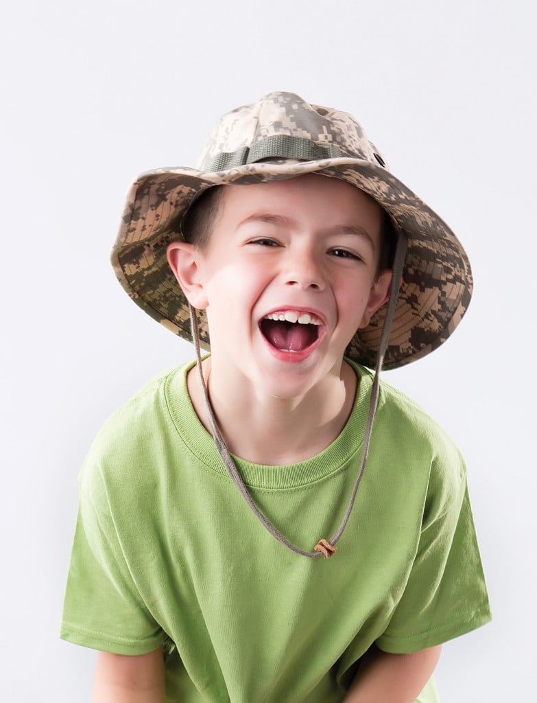 boy in green tshirt and camo bucket hat. for article on day camp