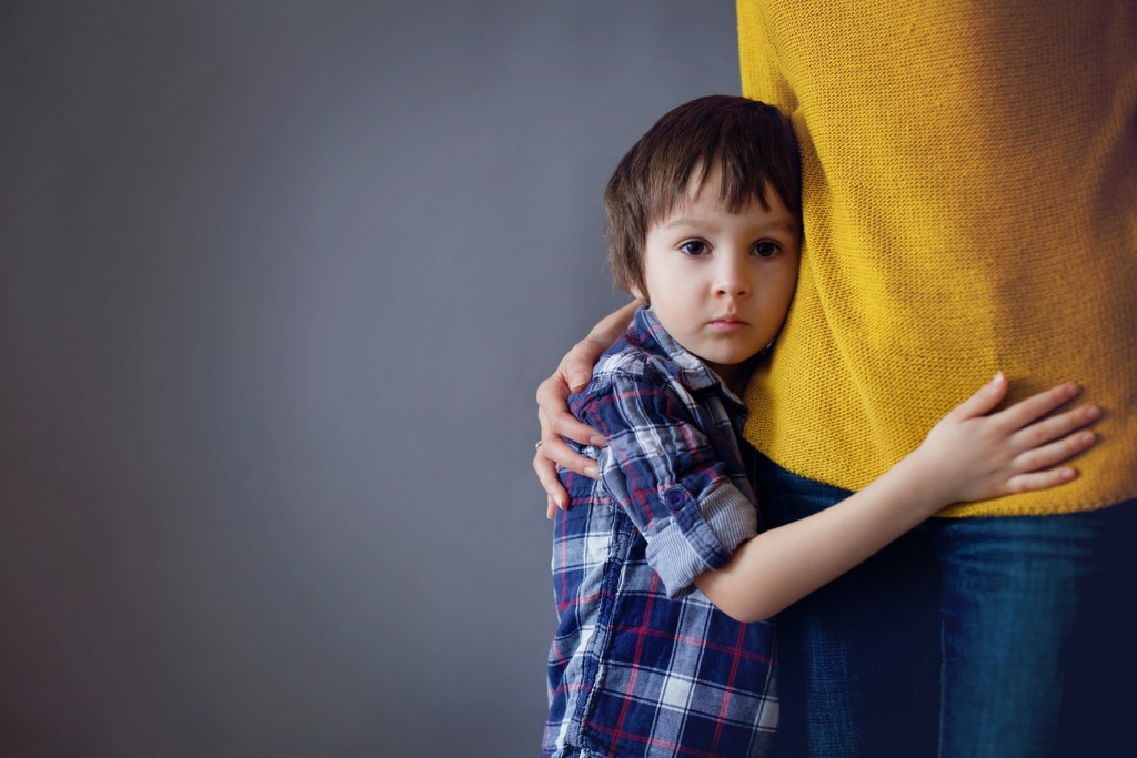 sad boy hugging mom, for article on helping kids through stressful times