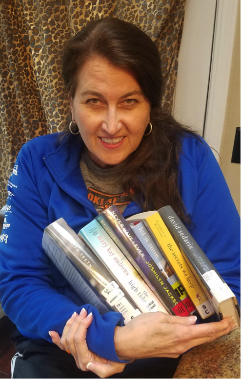 diane morrow kondos holding a stack of books, for article on decreasing anxiety