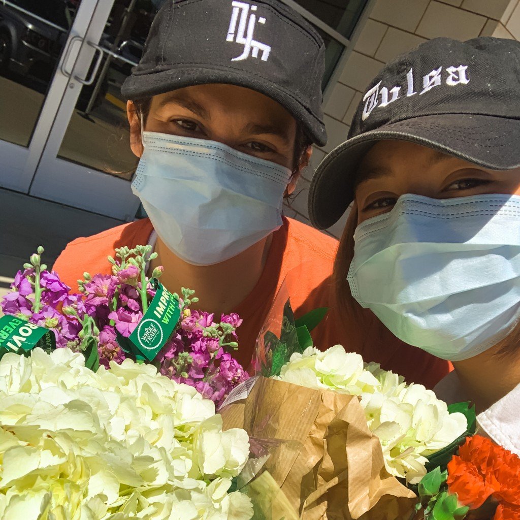 natalie hanson and a friend wearing masks and holding flower bouquets