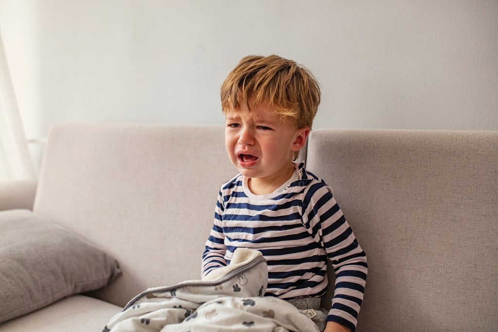 unhappy little boy on couch, for article on time-out mistakes