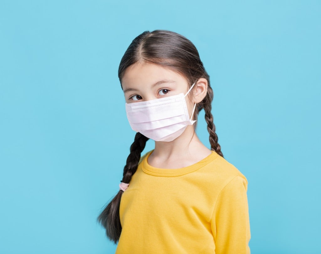 Sick Girl Child In Medical Mask Isolated On Blue Background