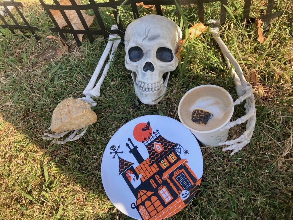 skeleton on ground holding latte, for article on fall drink menus in tulsa