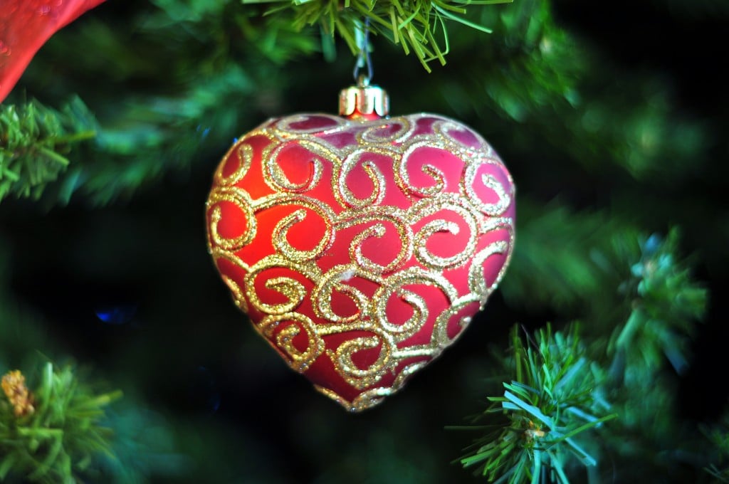Pretty Red Heart Shaped Festive With Gold Swirl Patterns Hanging From Artificial Christmas Tree