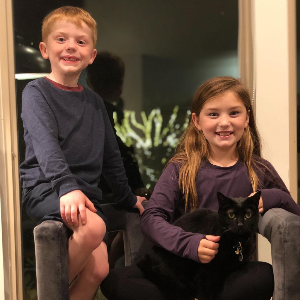 a boy and girl with a black cat, for article on pet death
