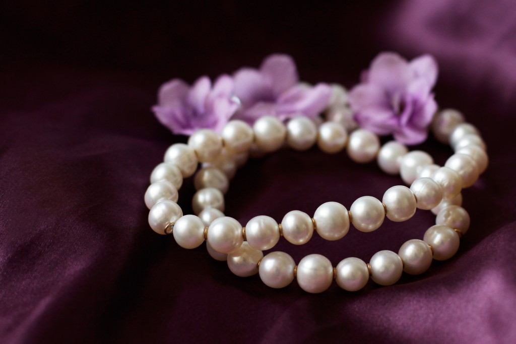 Pearl Necklace On Purple Background
