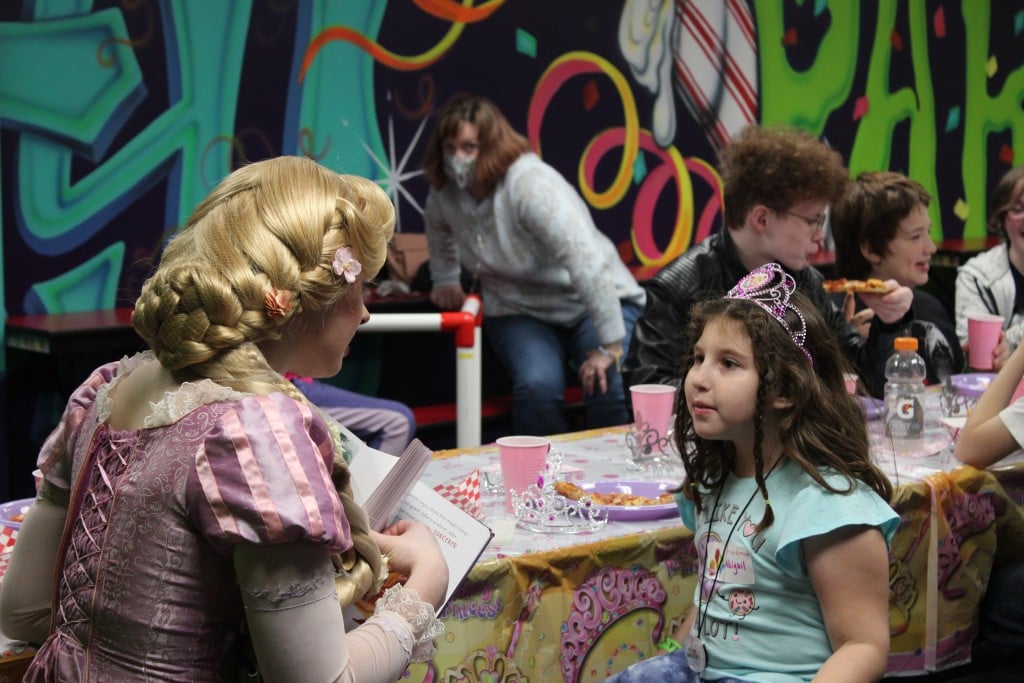 a young girl speaks to a princess character, for article on wheels and thrills birthday parties