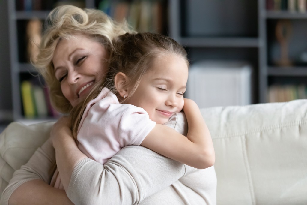 grandmother hugging grandchild, both smiling. grandparents' visitation rights concept