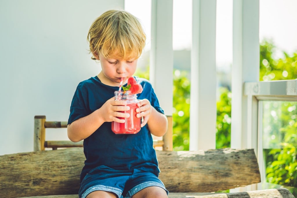 a young boy drinking a pink smoothie. Learn to make your own smoothies