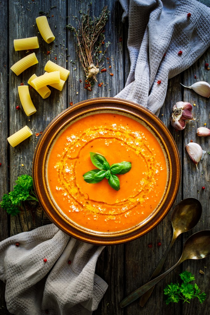 Cream Tomato Soup With Parmesan On Wooden Table
