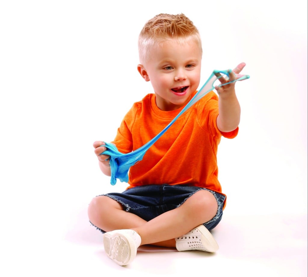 a young boy plays with slime, for article on summer activities for kids