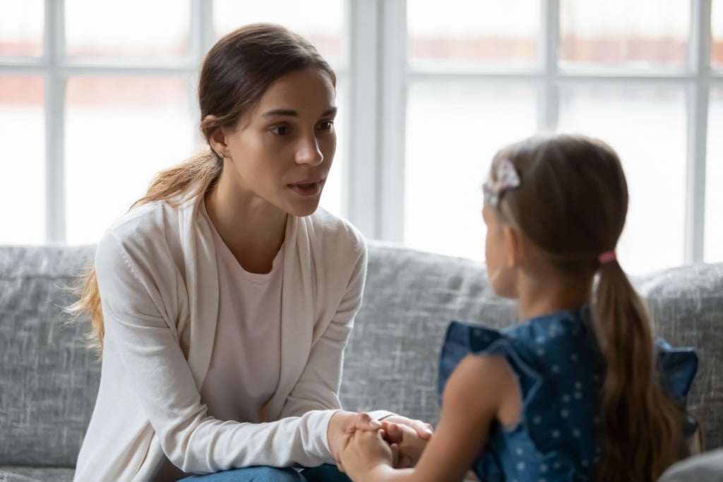 Worried Young Mommy talking to daughter, for article on talking to kids about traumatic events