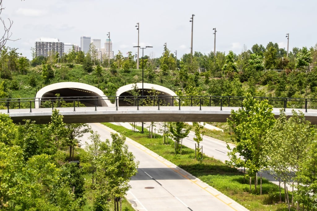 Looking Out Over Highway Tunnel And Pedestrian Overpass Near Park And Arkansas River With Newly Planted Trees And Wildflowers And Skyline Of Tulsa In Distance Selective Focus