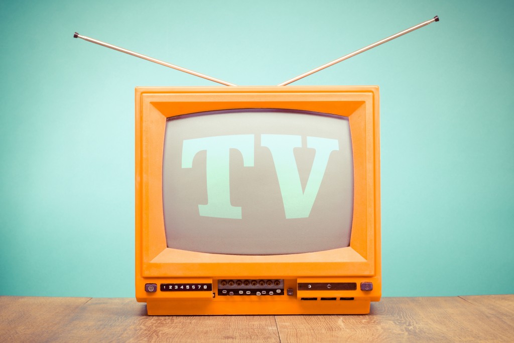 Retro Old Orange Tv Receiver On Table Front Mint Green Wall Background. Vintage Style Filtered Photo