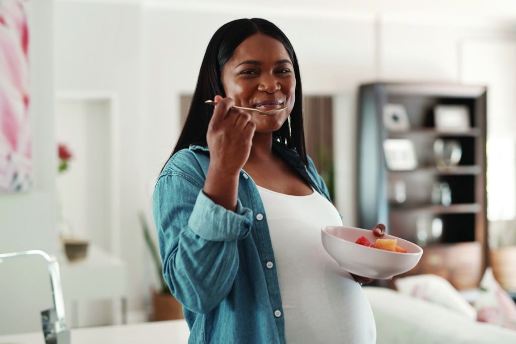 pregnant woman eating, for article on pregnancy and weight gain
