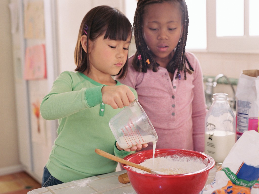 two girls baking together, for article on making math fun in the kitchen