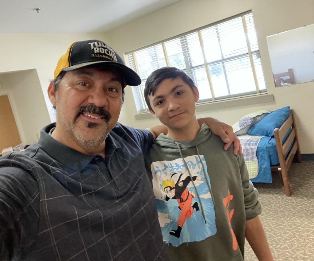 lynn hernandez and his son in his new room at boarding school