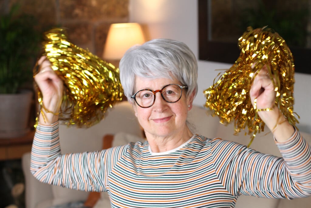 Senior Female Cheerleader At Home, for article on grandparents being cheerleaders for their grandkids