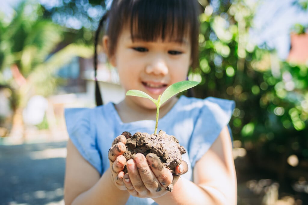 child holding plant, for article listing earth day events in tulsa