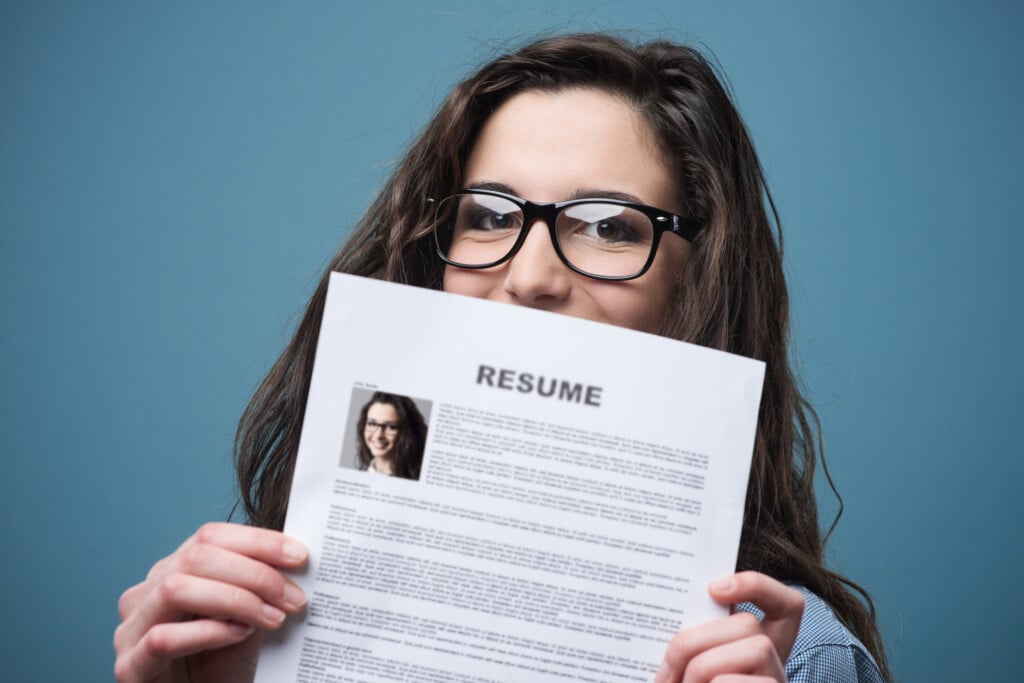 young woman holding her resume, for article on building a teen's resume