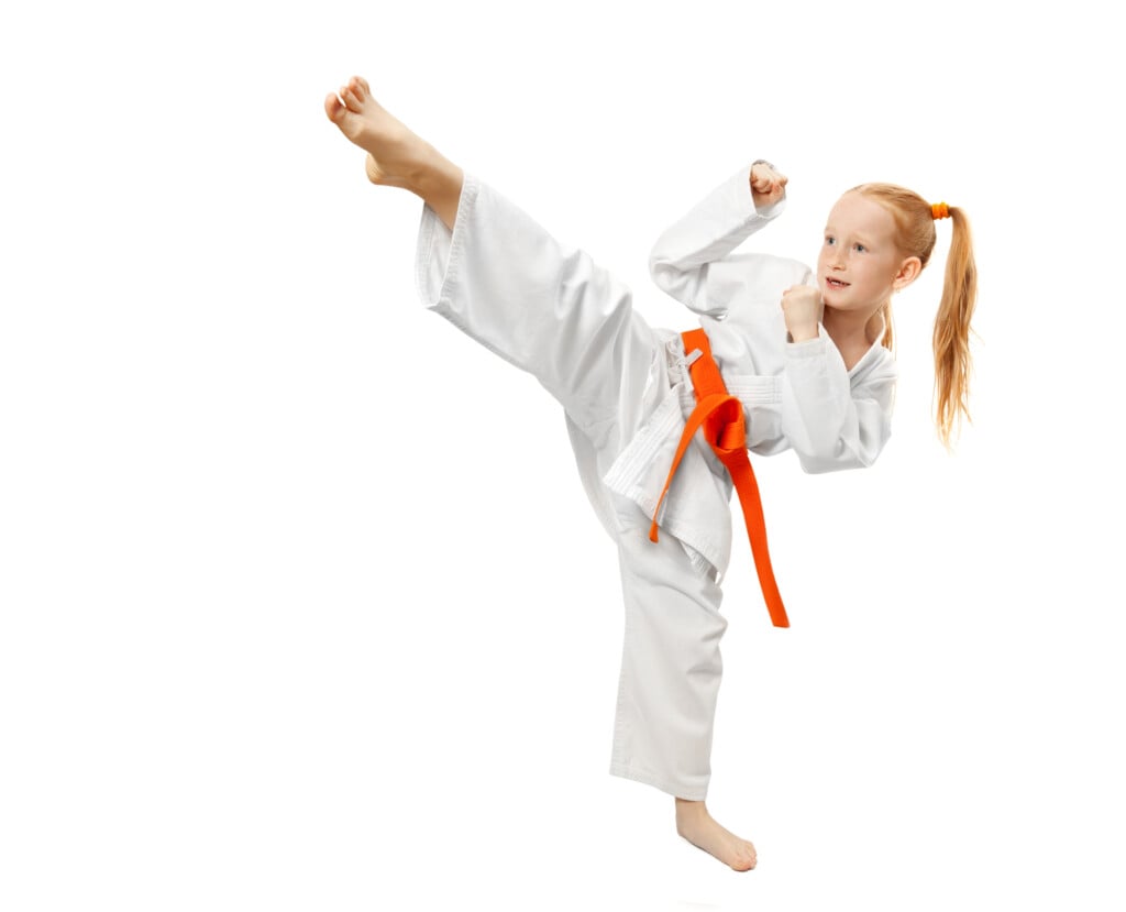 girl doing a martial arts kick, for article on after-school activities