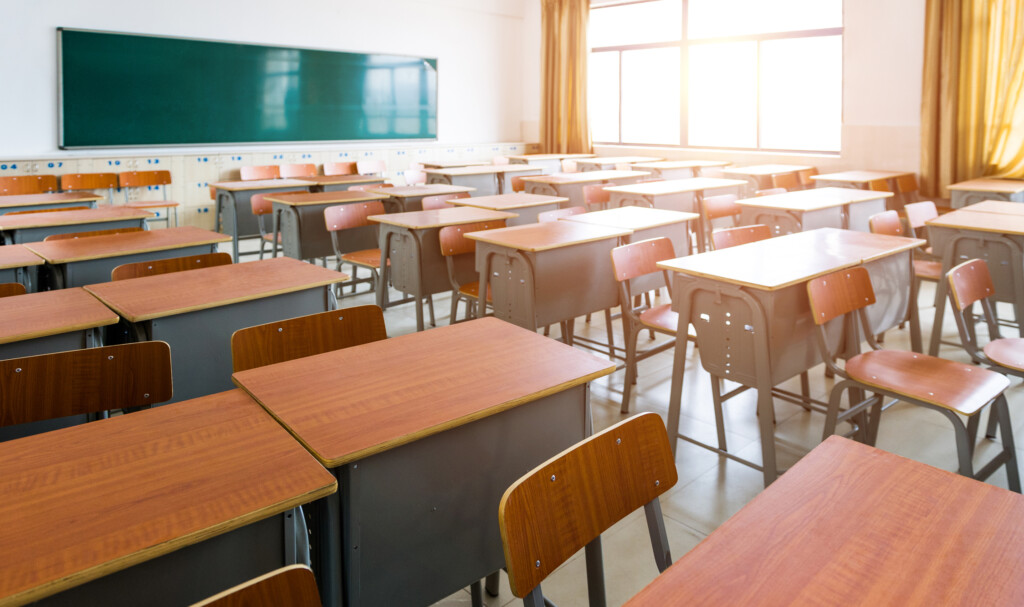 Empty Classroom With Desks, Chairs And Chalkboard