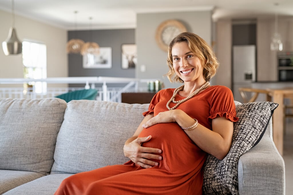 Sleeping pregnant woman is resting on the yellow chair Stock