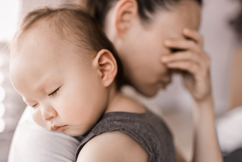 Tired Stressed Mother Holding Baby, for article on postpartum depression