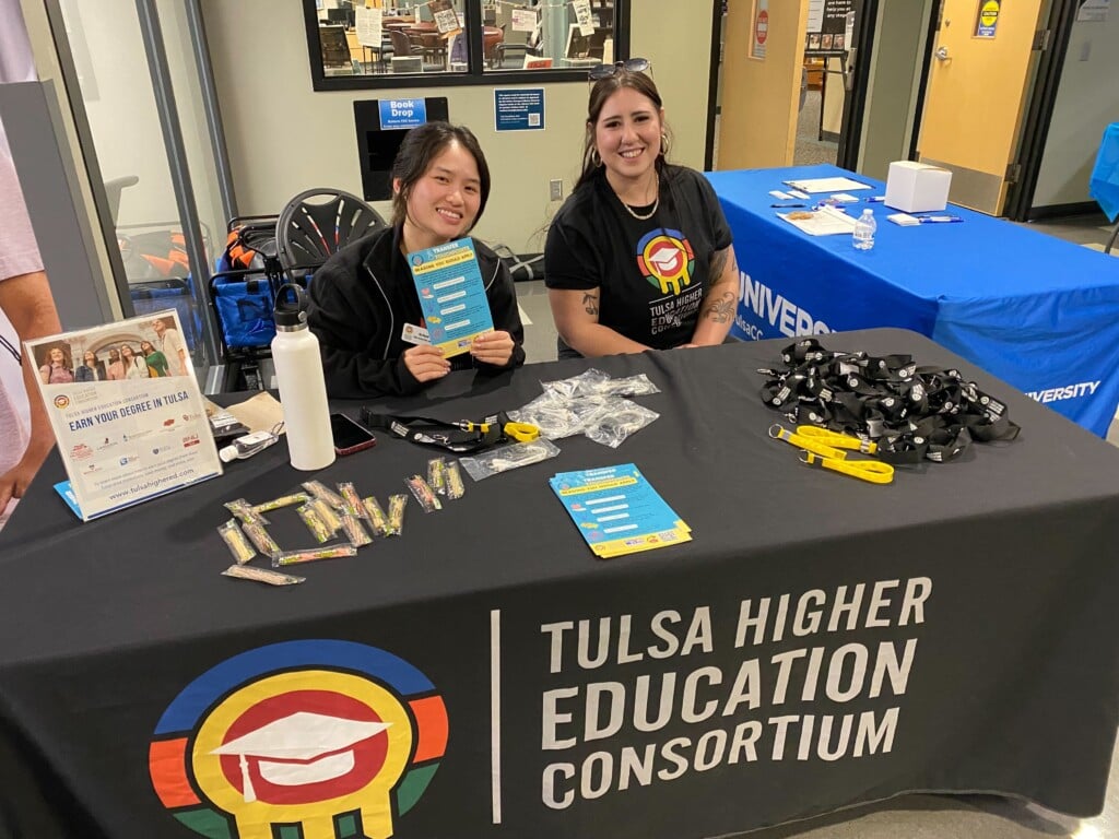 two young adults sitting at a booth for tulsa higher education consortium