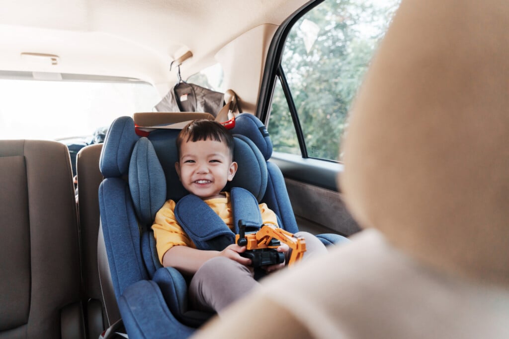 smiling little boy in car seat