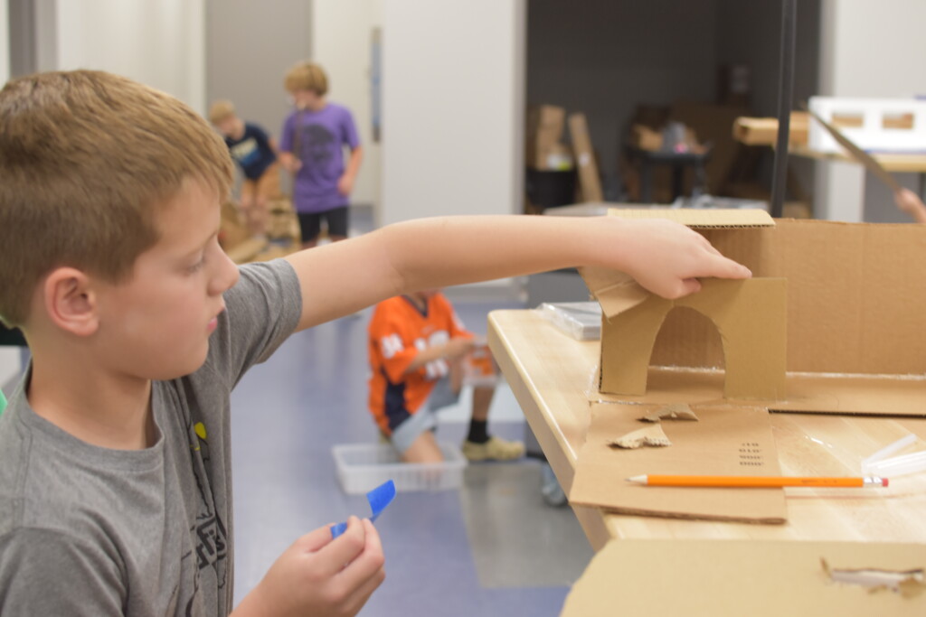 a student builds with cardboard in the Riverfield Center for Creativity