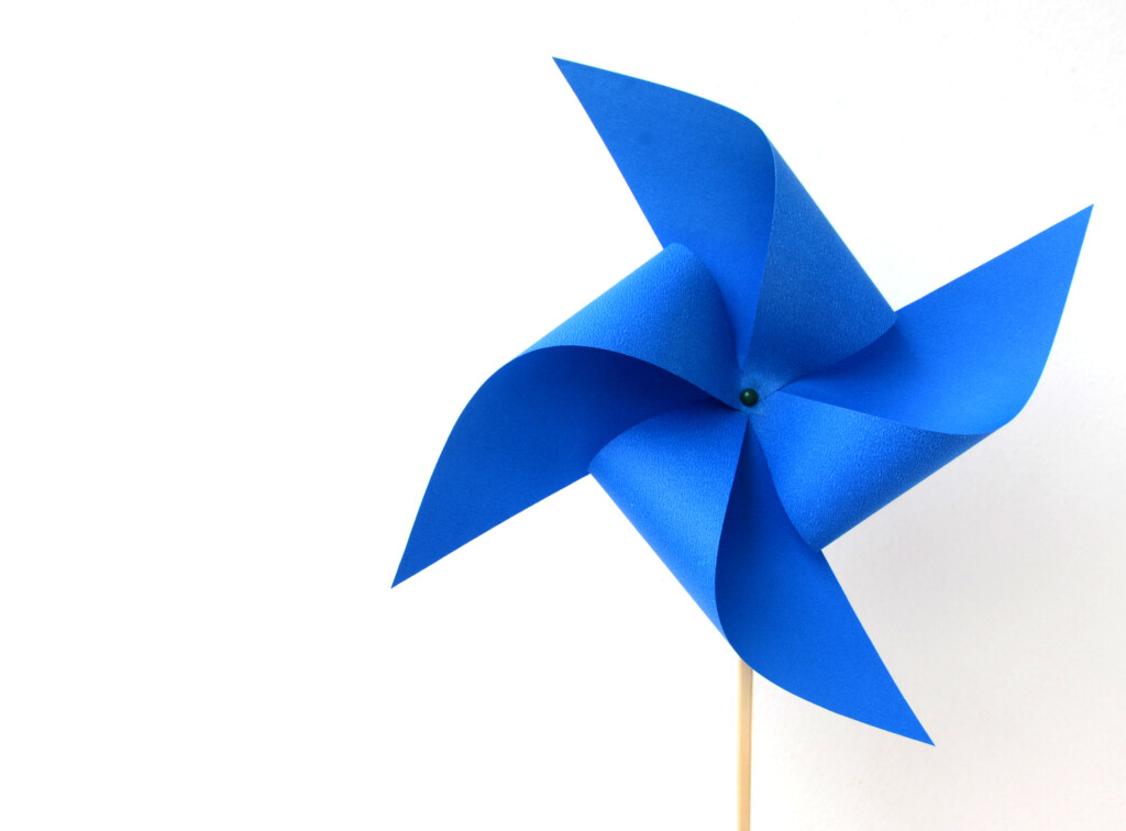 A Blue Paper Windmill On A White Background