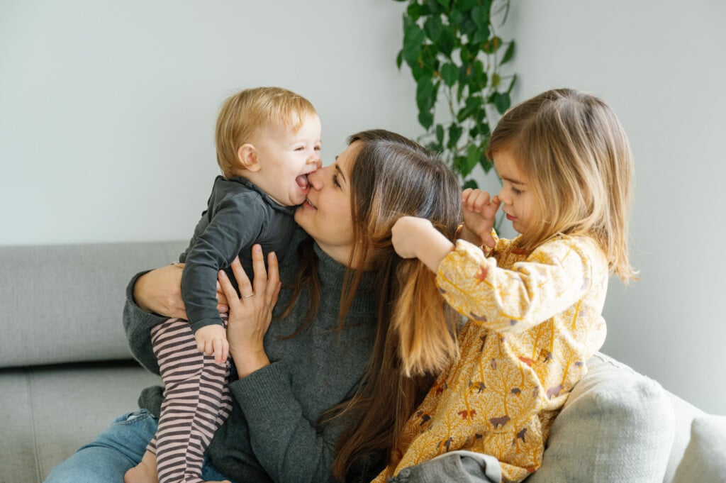Mother And Two young children laughing on a sofa