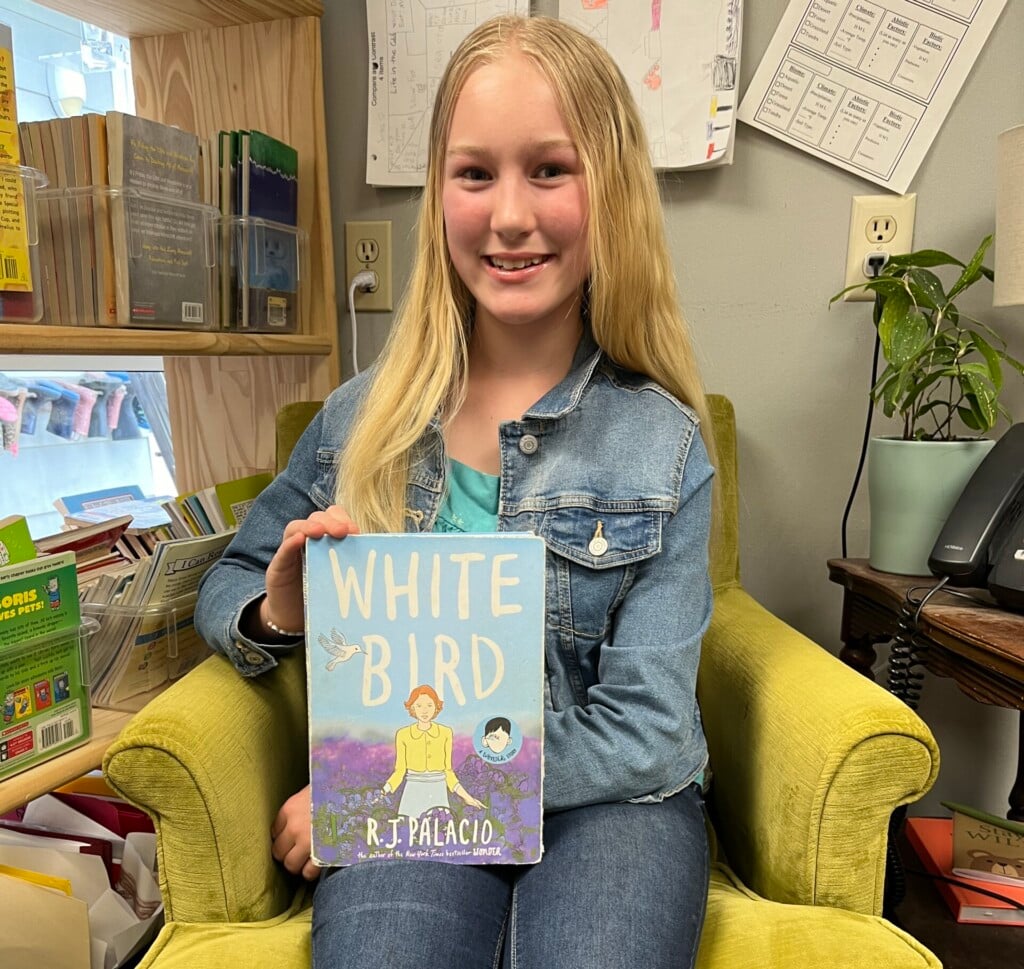 evelyn johnson holds a copy of white bird by r.j. palacio