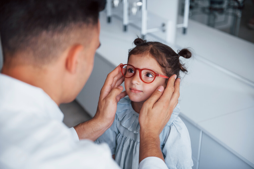 pediatrician helps child with glasses