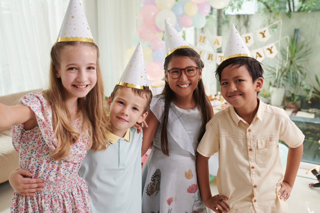 four elementary aged kids at a birthday party, for article on birthday party etiquette